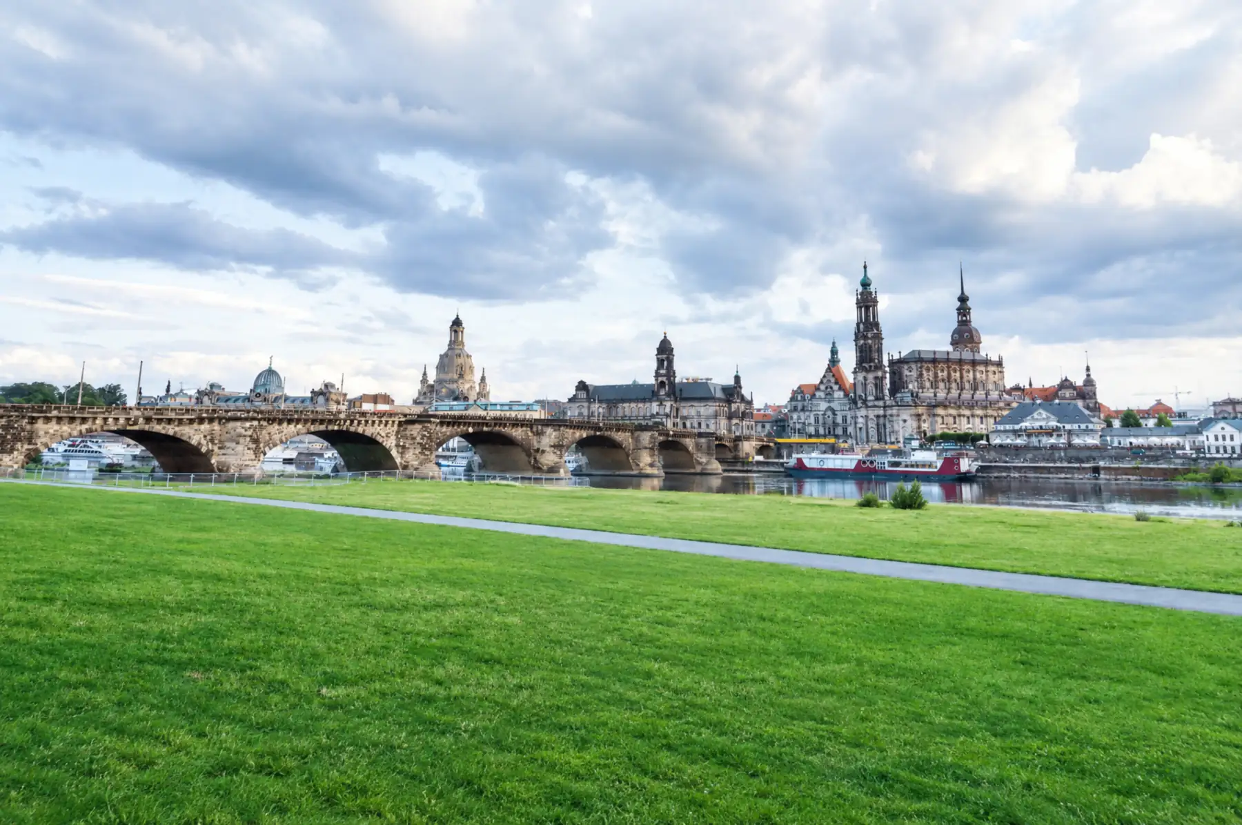 Blick über die Elbwiesen auf die Dresdner Altstadt mit Augustusbrücke, Frauenkirche und Hofkirche unter Wolken