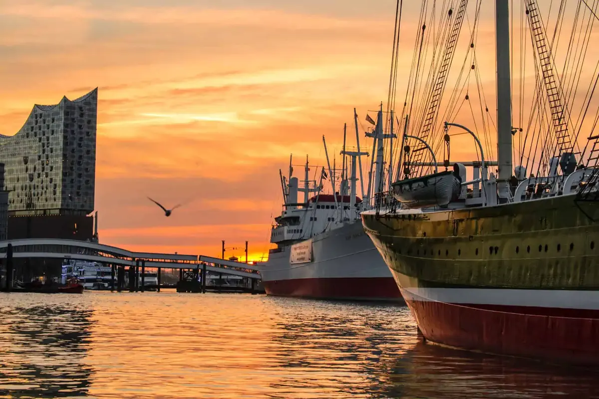 Hamburger Hafen im Abendrot: Museumsschiffe an den Landungsbrücken, links die Elbphilharmonie